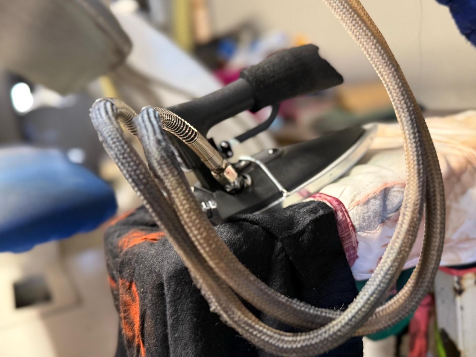 Professional industrial steam iron pressing a garment at IMIG Park Cleaners